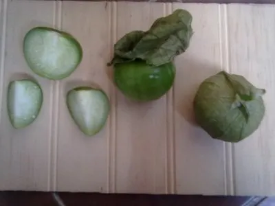 Tomatillos fra højre med skal, i midten af skallet, tv i ½ og 1/4