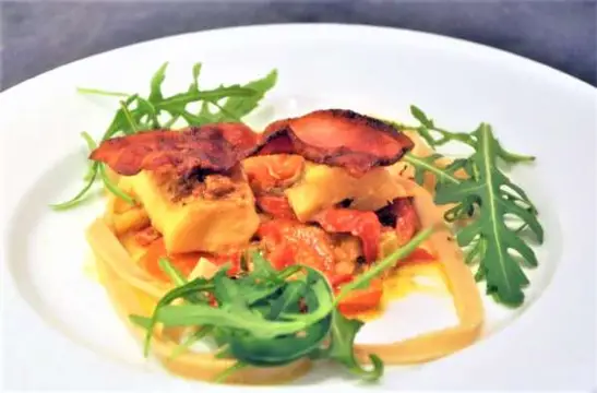 Havkat i fad med grønsager og bacon