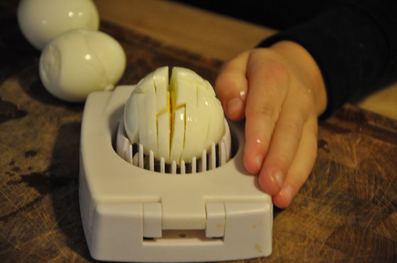 Lue bruger en æggedeler til at skære æggene i små stykker